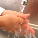 Kontaktfreie Wäsche der Hände, das Knie startet das Wasser